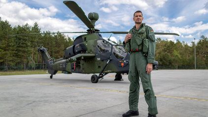 Hubschrauberpilot steht vor Kampfhubschrauber Tiger