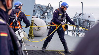 Soldaten der Marine ziehe an Bord eines Schiffes eine Boje aus dem Wasser