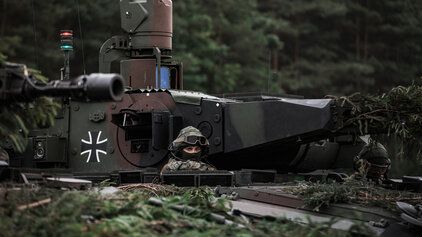 Ein Soldat der Bundeswehr schaut aus einem Panzer heraus.