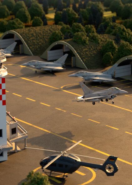 Eine animierte Ansicht des Bereiches "Luft" zu sehen sind Kampfjets der Bundeswehr auf einem Rollfeld. Ein Hubschrauber ist ebenfalls dargestellt. 