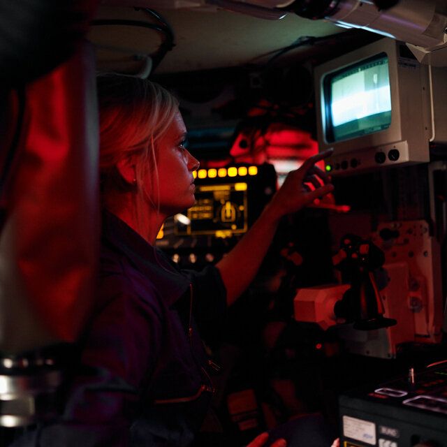 Eine Elektronikerin bedient einen Monitor in einem Schützenpanzer.