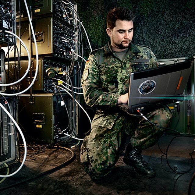 Ein IT-Soldat überprüft mit seinem Laptop den Server.