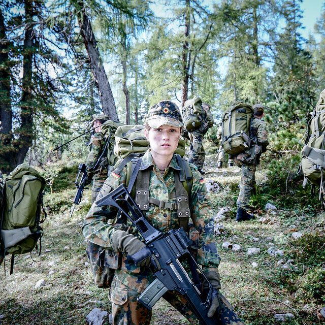 Soldat_innen der Bundeswehr stehen auf einem Hügel und schauen in alle Himmelsrichtungen. 