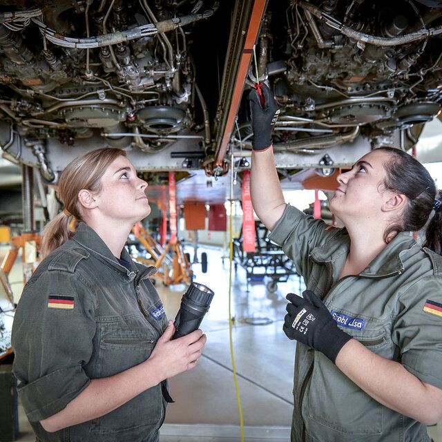 Zwei Fluggerätmechanikerinnen der Bundeswehr überprüfen im Innenraum eines Flugzeuges die Technik. 